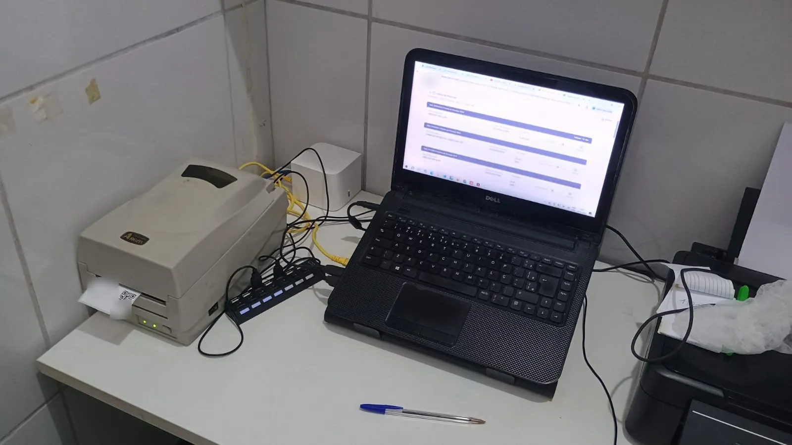 Notebook com o Norte Estoque aberto ao lado da impressora térmica de etiquetas